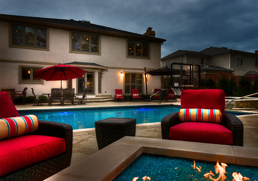 Backyard pool and fire pit at dusk